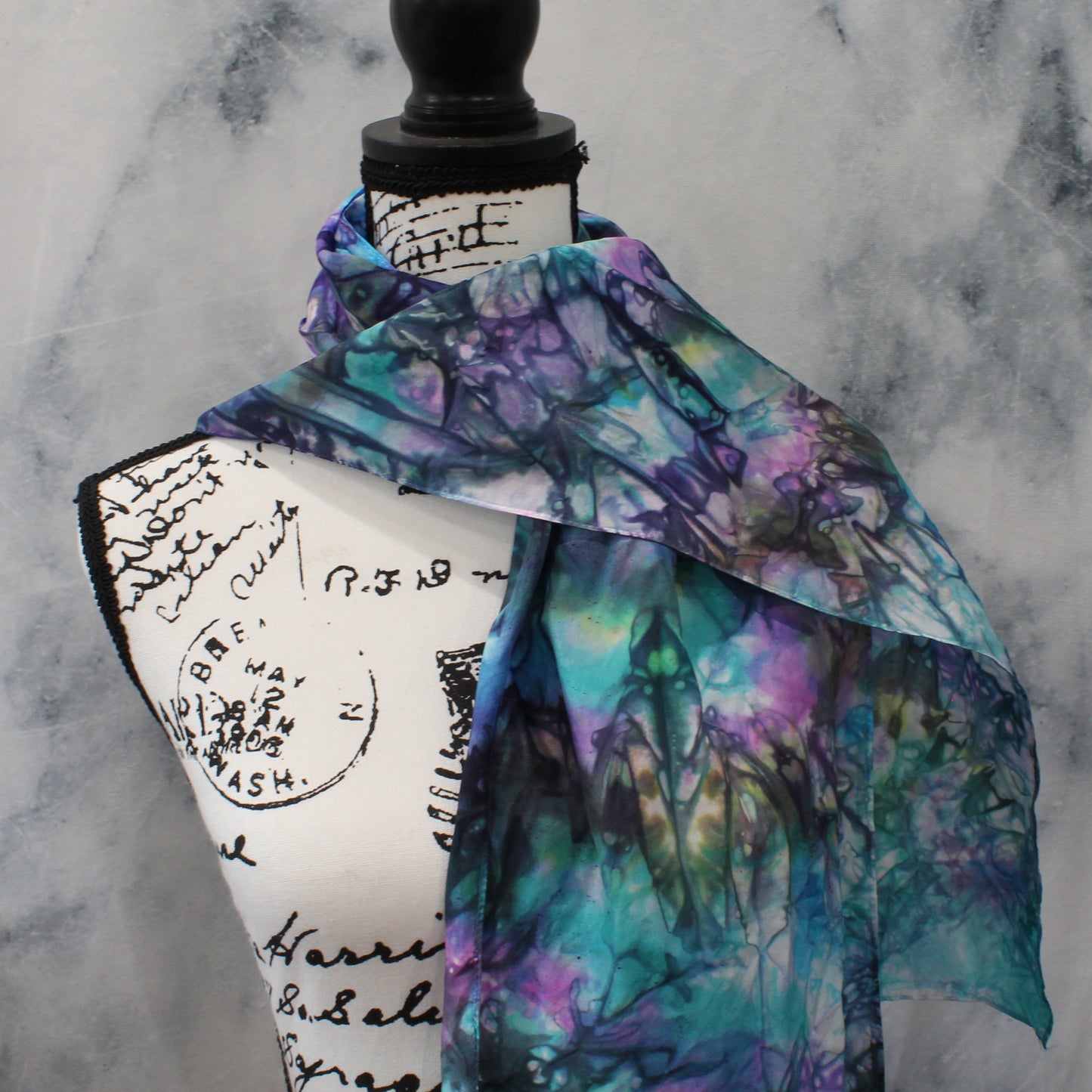 Colorful scarf on a mannequin against a marble background