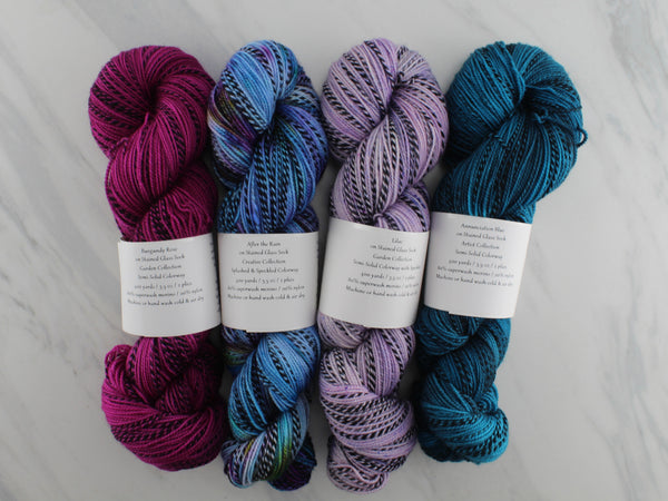 AS YOU WISH by Mary Annarella of Lyrical Knits - CURATED YARN SET #7 with After the Rain, Annunciation Blue, Burgundy Rose, and Lilac on Stained Glass Sock